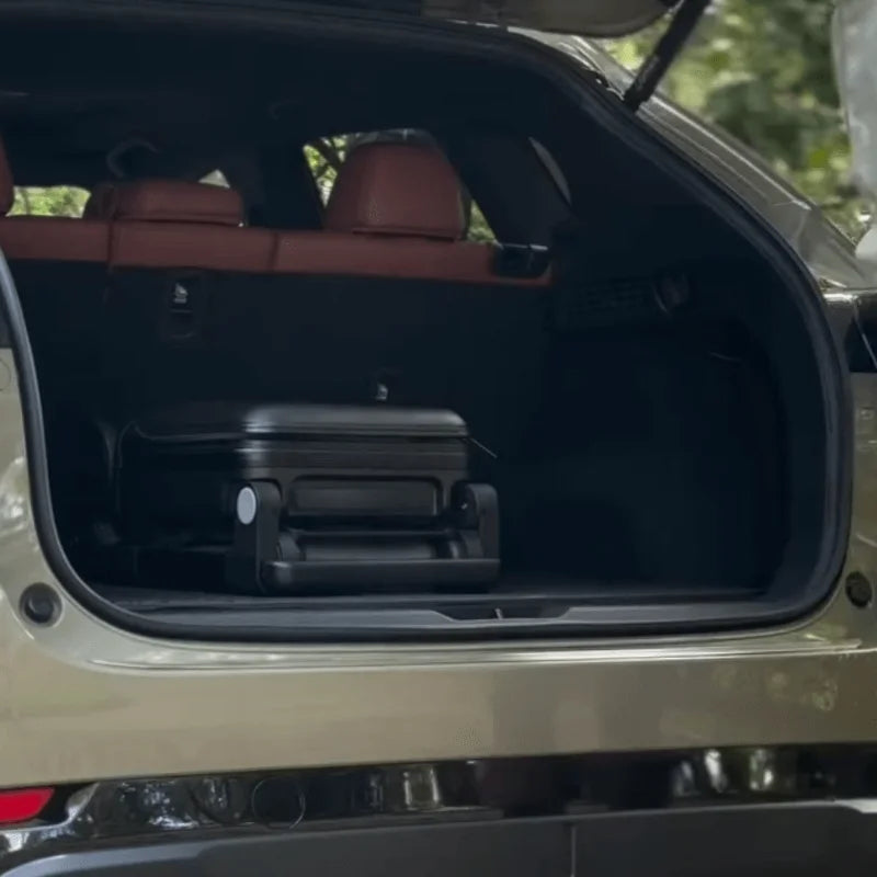 Open car trunk with TernX suitcase stroller inside.