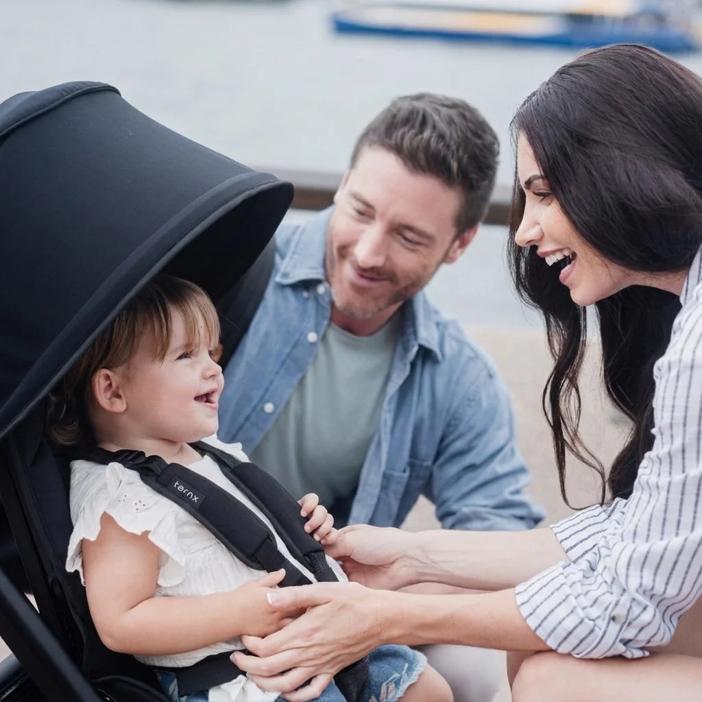 Family with a child in a TernX stroller by a waterfront