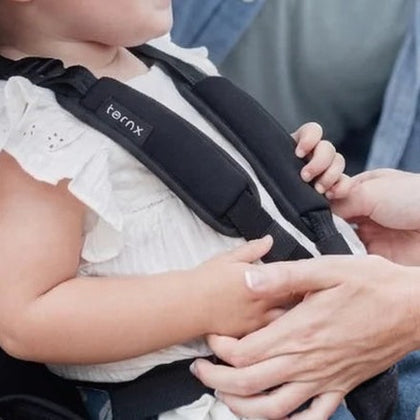 A child fastened into the TernX five-point harness